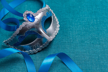 Beautiful carnival masks with a blue ribbon, on a turquoise background. Concept for the holiday...