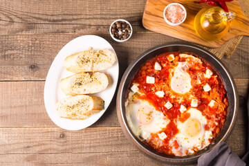 Shakshuka made of poached eggs in tomato pepper sauce
