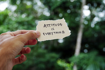 attitude is everything - Hand holding torn paper motivational slogan Inspirational Typography Quote...