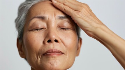 A serene elderly woman with closed eyes her head gently cradled by a hand evoking a sense of peace and tranquility.