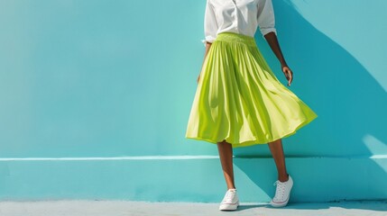 A woman in a white blouse and yellow skirt standing against a blue wall with a shadow cast behind her. - obrazy, fototapety, plakaty