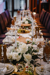 Food and drink on the dining table. Serving, setting table in the hall.  Plate and glass, luxury rich decor. Wedding set up, dinner table reception in a restaurant. Birthday, baptism, event.