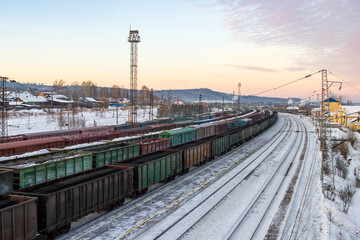 Fototapeta na wymiar Delivery of goods by rail. Top view of freight railway cars. Freight trains with coal and cargo. Transport infrastructure and cargo transportation. Baikal-Amur Mainline (BAM), Eastern Siberia, Russia.