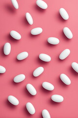 White Pills Scattered on Pastel Background