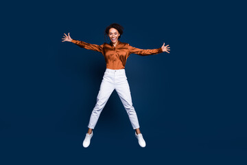 Fototapeta na wymiar Full length photo of lovely young lady jumping star excited dressed stylish brown silk formalwear isolated on dark blue color background
