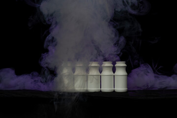 Small white plastic bottles with dramatic smoke background