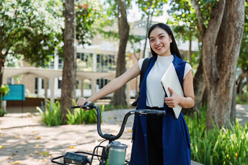 Young businesswoman sitting on stair in city park and using laptop for work hybrid. Bike to work eco friendly alternative vehicle green energy