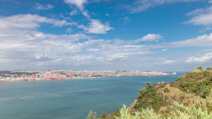 Fototapeta na wymiar Panorama showing Lisbon cityscape and Tagus river timelapse with 25 of April bridge