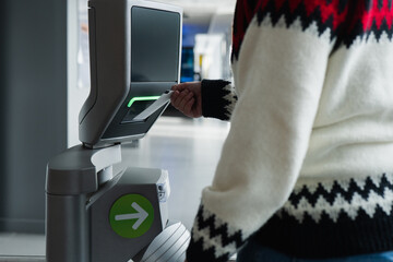 Anonymous visitor using ticket machine at museum entrance