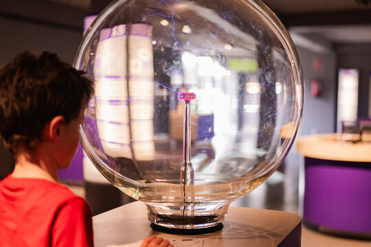 Curious child engaging with science exhibit at museum