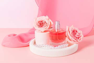 Beautiful bottle of perfume or cosmetic spray, jar of face skin care cream on white plaster tray with roses. Cosmetics and beauty concept.
