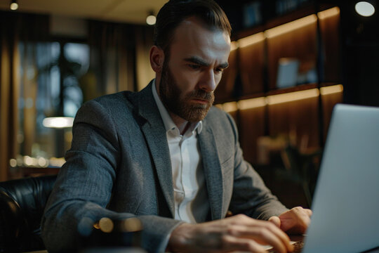 Focused Caucasian business man typing at laptop in office closeup. Guy surfing internet