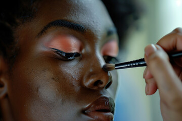 Makeup artist applies Makeup artist applies powder and blush . Beautiful African American Woman face. Hand of make-up master puts blush on cheeks beauty model girl. Make up in process .