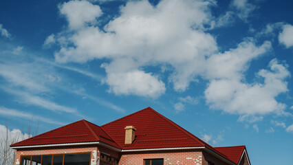 Panoramic close-up shot of the roof of a modern house against a blue sky background.
