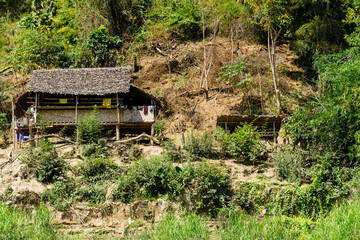 A small house on a hill next to a river in Thailand.