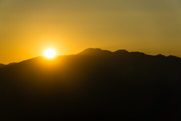 The sun sets among the mountains.