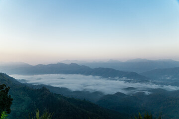 Fototapeta premium Misty mountain landscape, clear blue cloudless sky and layers of hills. Cold mood.