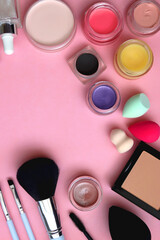 Various colorful beauty products on bright pink background. Top view.