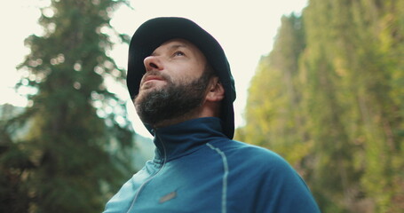 Male traveler, portrait close-up. Travel, hiking and camping concept happy man with cup camping in the forest.