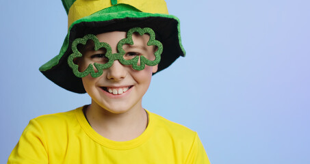 St. Patricks day banner. Portrait of joyful kid in clover shaped glasses.