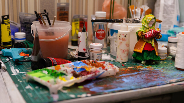 The Artist's Colorful Workspace: A Table Laden with Paints, Creating a Working Atmosphere