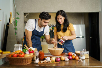 Man and woman making a pizza.