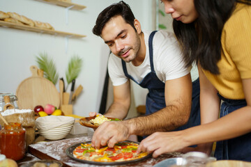 Man and woman making a pizza.