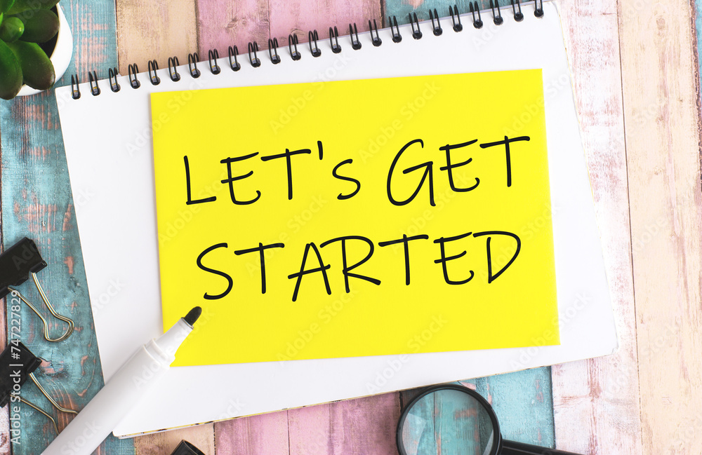 Aufkleber text let's get started on yellow paper composition with stationery on color background