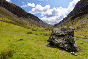 Fototapeta na wymiar A large slate rock sits by the road in the valley of Honister Pass Cumbria in the Lake District of England UK