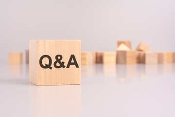 text 'Q and A' on wooden block, gray background