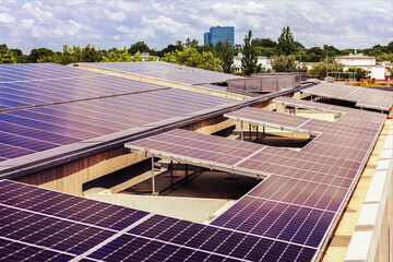 Solar Panels Roof Multifamily High-rise Building on Green City Background with Skyscrapers. Solar...