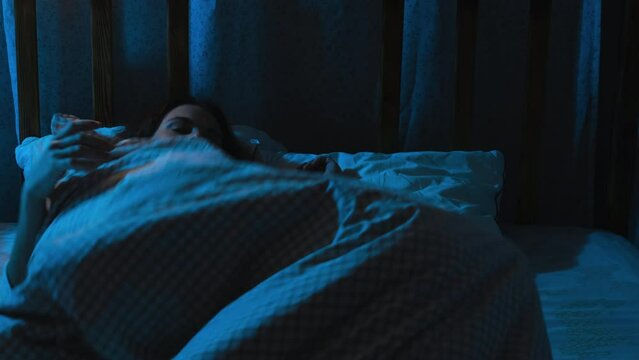 Insomnia. Woman tossing and turning, lying awake at night. 