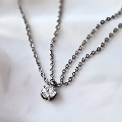 Radiant Allure: A Silver Chain Necklace with a Dazzling Diamond Pendant, Set Against a Whimsical White Backdrop