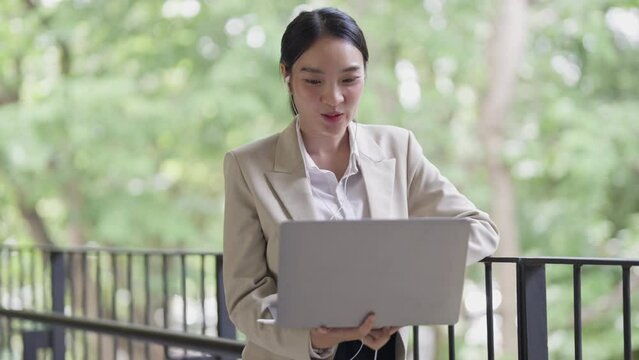 Asian woman online greetings with colleague on laptop
