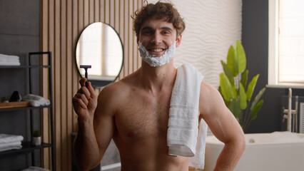 Portrait Caucasian bearded unshaven bristle man posing naked with white bath towel on shoulder...
