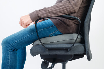 man uses a ring cushion to seat