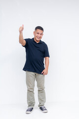 Full-body portrait of a cheerful middle-aged Asian man giving a thumbs up sign, standing against a...