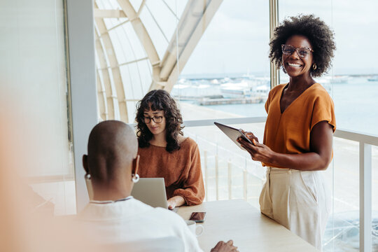 Business woman having a collaborative business meeting with her colleagues in a modern office - Powered by Adobe
