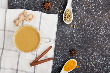 Traditional healthy masala tea - indian drink with spices turmeric, star anise, cardamom on the...