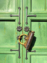 a fragment of an old green wooden door, upholstered in metal and closed with an old bronze padlock. Door is located in the Gyeongbokgung Palace complex of Joseon dynasty, built in 1395.