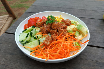 Salad with tempeh and vegetables on wooden background