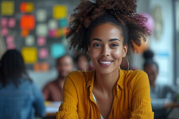 Radiant young woman with curly hair, gold hoop earrings, smiling in a collaborative office space.