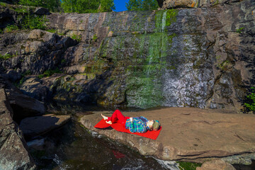 beautiful mature women doing gymnastics on a mat in the Mountain Gorge in the Southern Urals