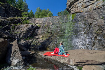 beautiful mature women doing gymnastics on a mat in the Mountain Gorge in the Southern Urals