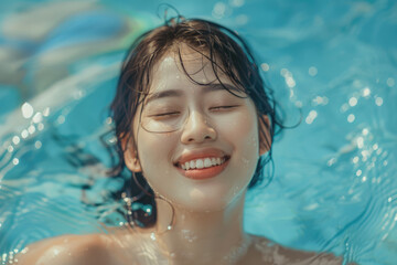 Fototapeta na wymiar Young happy Asian woman relaxing with eyes closed in swimming pool