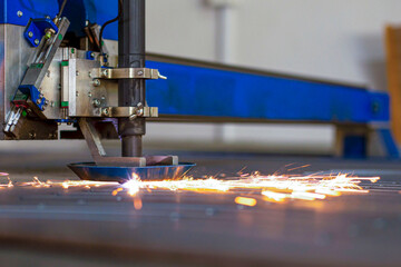 close-up laser cutting of metal on a CNC machine, at a large machine-tool plant in the center of...