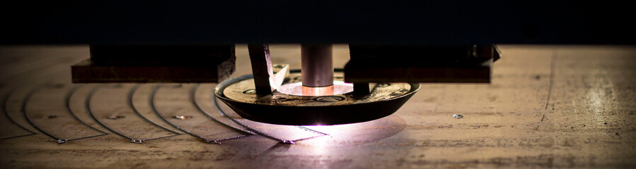 close-up laser cutting of metal on a CNC machine, at a large machine-tool plant in the center of...