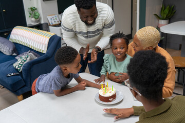 Family with children (2-3, 6-7, 12-13) celebrating birthday at home