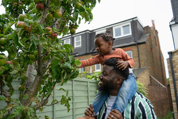 Father giving daughter (2-3) piggyback ride