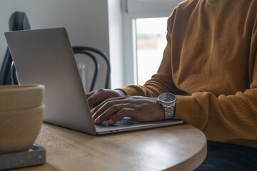 Mid section of man using laptop at table